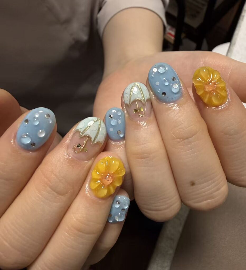 ブルーの水滴アートとイエローフラワーの3Dネイル
Blue raindrop nails with yellow 3D flower art
